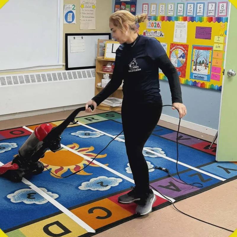 Vacuuming a classroom rug at a daycare